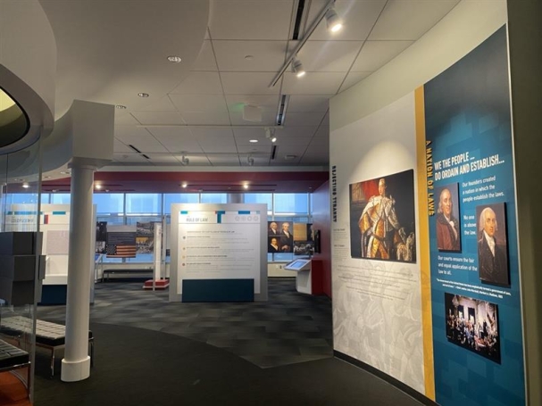 Judicial learning center with Ben Franklin and George Washington displayed on one wall, and a walkway to the entrance of the museum.